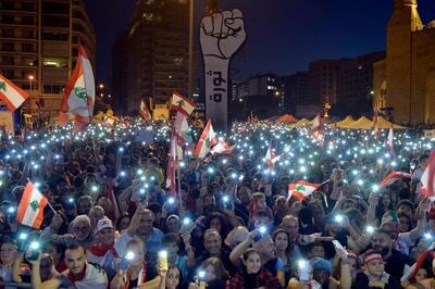 Lebanese protesters light up their phones next to a fist-shaped banner reading 'Revolution' during a protest called the Peaceful Challenge, in Martyrs' Square. EPA