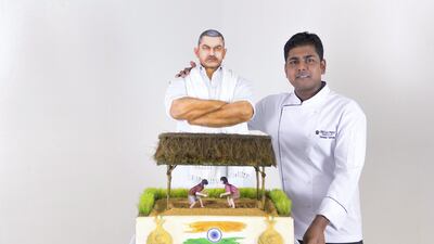Head chef, Dominic Joseph Samuel, stands next to a replica of a Dhs150,000 gold coated cake, in Broadway Bakery. Reem Mohammed / The National