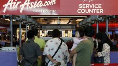 People queue at an AirAsia counter at Changi Airport in Singapore. The low-cost carrier has reported a surge in profits. Edgar Su / Reuters