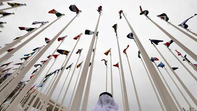 An Emirati visitor stands beneath the waving flags of countries participating in the Expo 2020. Gulf countries experienced a solid expansion in non-oil sectors in the first quarter of 2022. AFP