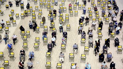 People wait to receive Covid-19 vaccine doses at the Iran Mall shopping centre, in Tehran, Iran.
