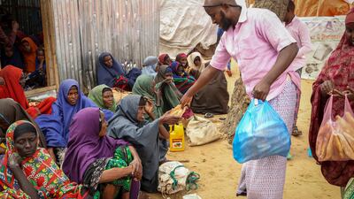 Somalis who fled drought-stricken areas receive food donations from city residents at a makeshift camp on the outskirts of Mogadishu. AP