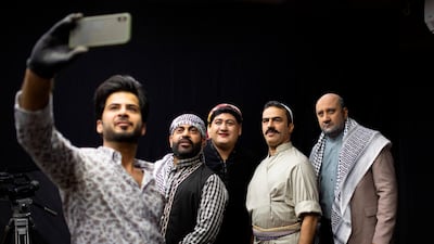 The set's makeup artist (L) takes a selfie photograph as he poses with Iraqi actors (L to R) Ayad al-Atabi, Oussama Mahdi, Youssef al-Hajjaj, and Mohammad Qassem on the set of a parody sketch video of Bab al-Hara, an adaptation of an iconic long-running Syrian television drama, in Iraq's southern port city of Basra on April 22, 2020. AFP / Hussein Faleh