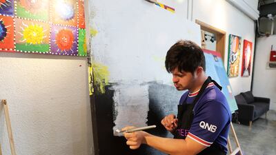 Marwan Al Khaja working on a painting at the studio in Al Quoz. Pawan Singh / The National