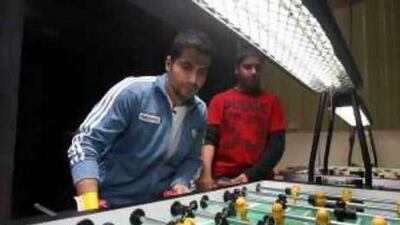 Twist again: Miqdad al Suwaidi (left) plays foosball at the Tornado Sports Cafe, which he owns.