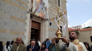 A clergyman holds a crucifix outside St Georges Church in qlayaa on Easter Sunday. Reuters