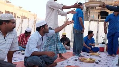 Volunteers and worshippers divide a Zakat meal in preperation for Iftar at a portacabin mosque.