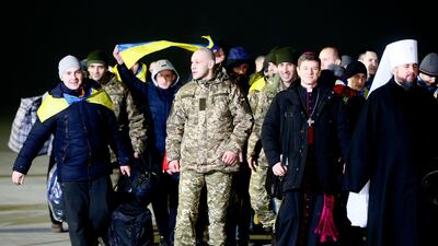 Prisoners who were released by separatists, accompanied by clerics and officials leave the plane after landing in Kiev Boryspil Airport, Ukraine, early Thursday. Efrem Lukatsky / AP