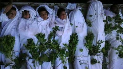 The shrouded bodies of Syrians, including children, during a funeral in Daraya, near Damascus.