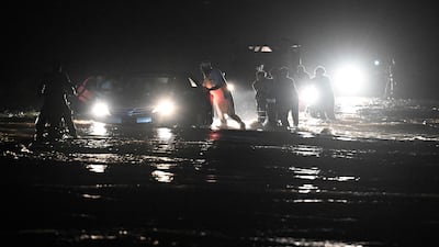 Residents wade through a flooded street in Khyber Pakhtunkhwa province. The unusually intense monsoon season has left more than 250 people dead in recent days. AFP
