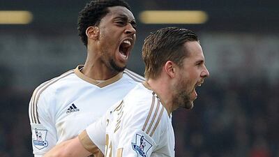 Swansea City’s Gylfi Sigurdsson, foreground, celebrates scoring his side’s second goal with teammate Leroy Fer, during the Premier League match between AFC Bournemouth and Swansea City, at the Vitality Stadium, in Bournemouth, England, Saturday March 12, 2016. (Andrew Matthews/PA via AP)
