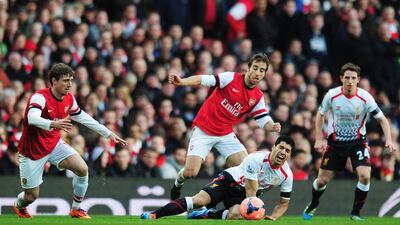 Luis Suarez, right, of Liverpool is tackled by Mathieu Flamini, centre, of Arsenal. Shaun Botterill / Getty Images