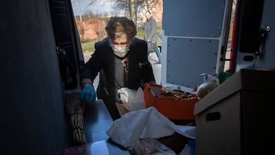 Galina Yakovleva sorts through donated goods in the back of her van, which she drives herself to make deliveries. AP Photo