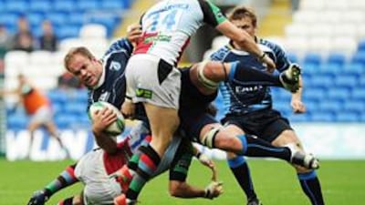 The Cardiff Blues' Xavier Rush is airborne as he is tackled by the Harlequins' Gonzalo Tiesi and David Strettle (14) yesterday.