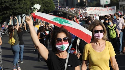 People wave Lebanese flags and chant to mark the first anniversary of anti-government protests. Getty Images