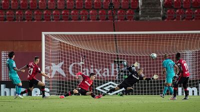 Lionel Messi (L) scores against Mallorca inside an empty Son Moix Stadium. AFP