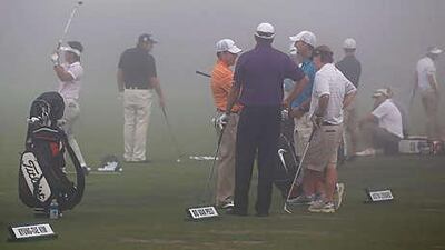 Players hit on the practice range during a fog delay in the first round of the 92nd PGA Golf Championship at Whistling Straits.