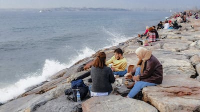 People enjoy their lunch by the seaside, at Kadikoy in Istanbul. AFP