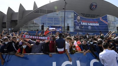 Supporters cheer as Lionel Messi attends his unveiling press conference.