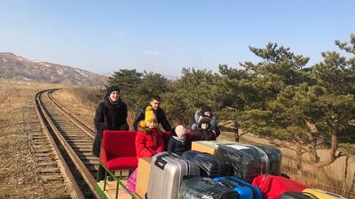 Russian diplomats and their family members use a hand-pushed rail trolley to leave North Korea. Reuters