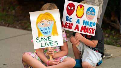 Lucie Phillips, 6, and her brother David Phillips, 3, join parents and students during a rally at Utah State School Board Office calling for mask mandate on August 6, 2021, in Salt Lake City. AP