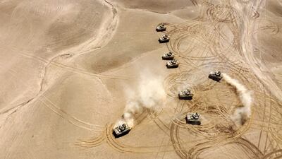 This aerial view shows troops from the Syrian Democratic Forces (SDF) Special Operations and the US-led anti-jihadist coalition, take part in heavy-weaponry military exercises in the countryside of Deir Ezzor in northeastern Syria, on March 25, 2022. (Photo by Delil SOULEIMAN / AFP)