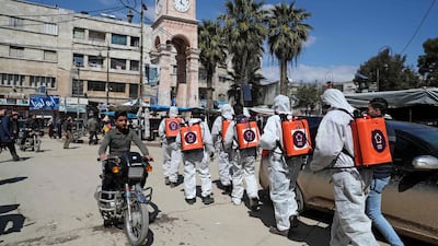 Members of the Syrian Violet NGO disinfect the streets of Syria's northwestern Idlib city. AFP