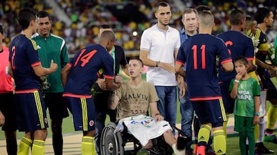 Former Chapecoense goalkeeper Follmann, in wheelchair, greets various Colombia's soccer players prior to a 2017 friendly match at the Nilton Santos stadium in Rio de Janeiro, Brazil, in tribute to Chapecoense soccer players who died in a plane crash in Colombia in 2016. (AP Photo/Silvia Izquierdo, FILE)