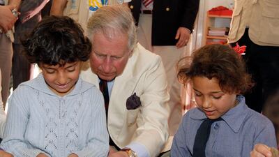 The then Prince Charles plays with children during a visit to King Abdullah Park for Syrian Refugees in Ramtha, north of Amman, Jordan, in March 2013. AFP