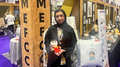 Emirati designer and animator Hamda Al Khaja in front of her table at the Artist Alley at Middle East Film and Comic Con. Faisal Al Zaabi / The National