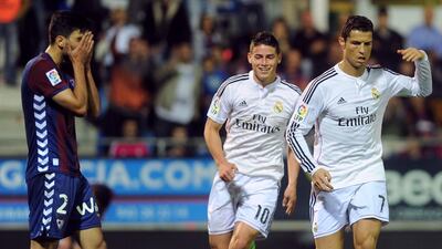 Real Madrid's Cristiano Ronaldo, right, celebrates next to teammate James Rodriguez and Eibar defender Eneko Boveda after scoring during their Primera Liga match at the Ipurua stadium in Eibar on November 22, 2014. AFP PHOTO / RAFA RIVAS