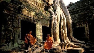 Monks at Ta Prohm. The Bayon-style temple in Angkor Thom became famous after it featured it the film Tomb Raider starring Angelina Jolie.