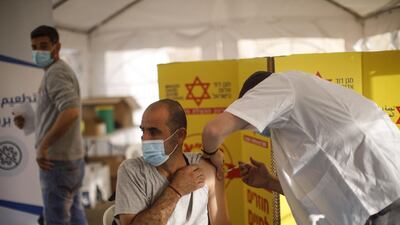 A Palestinian labourer receives a dose of the Moderna Covid-19 vaccine at a temporary vaccination centre at the Rachel's Tomb checkpoint crossing into Israel, in Bethlehem, West Bank. Bloomberg
