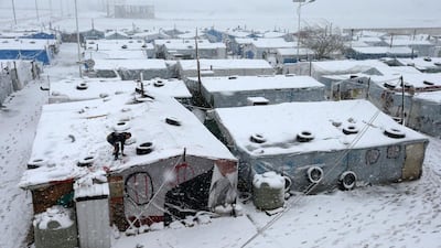 Inside the tents, adults could be seen huddling around the wood burning stoves to try to keep warm. Hussein Malla / AP Photo