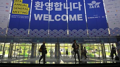 People walk past IATA banners during the annual general meeting of International Air Transport Association (IATA) at COEX convention and exhibition centre in Seoul on June 2, 2019. AFP