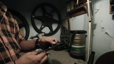 Pavlos Lepeniotis handles strips of film at the Zefyros vintage-movie cinema in Petralona, near central Athens.
