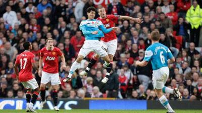 Sunderland's Ji-dong Won, in blue, jumps for the ball with Manchester United's Nemanja Vidic.