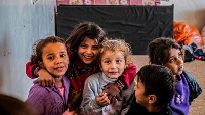 Internally displaced Syrian children pose for the camera at a school turned into makeshift camps in the northern Syrian city of Hasakeh. AFP
