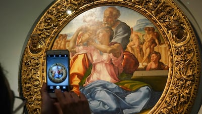 A member of the media takes a picture of 15th century painting 'Doni Tondo' by Michelangelo Buonarroti. AP Photo