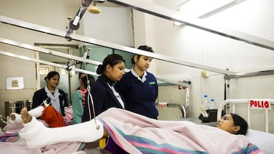 General Nursing and Midwifery Interns Julia, 20, left, and Leena 21, right, talk to 20-year-old polio victim Lata Sagar. The orthopaedic team at the hospital straightens deformed limbs and sometimes lengthens one leg to balance the other. Flailing joints are fused for stability. Calipers, braces and artificial limbs are made at the hospital, and physiotherapists spend months taking patients through exercises and training them to use their calipers.