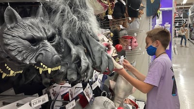 A young customer views Halloween masks. Americans continued to spend at a solid clip in September, despite rising prices and snarled global supply chains limiting the flow of goods. AP