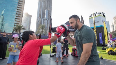 A young boy practising his boxing at the closing weekend carnival of the second year of the Dubai Fitness Challenge at Burj Park, Dubai. Leslie Pableo for The National