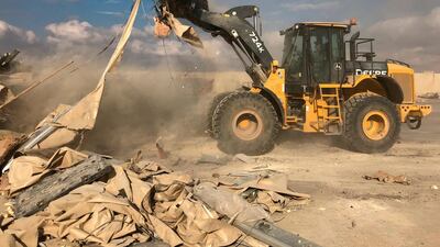 A bulldozer clears rubble and debris at Ain Al Asad air base in Anbar. AP