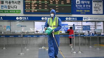 A worker wearing protective gear sprays disinfectant as part of preventative measures against the spread of covid-19 at a railway station in Daegu, South Korea. AFP