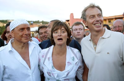 Then Italian premier Silvio Berlusconi, wearing a bandanna, with his guests Tony Blair, then British prime minister, and his wife Cherie Blair at Villa Certosa on August 16, 2004. AP Photo