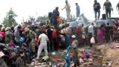 Uzbekistan soldiers and security officers assist ethnic Uzbeks fleeing violence in southern Kyrgyzstan yesterday.