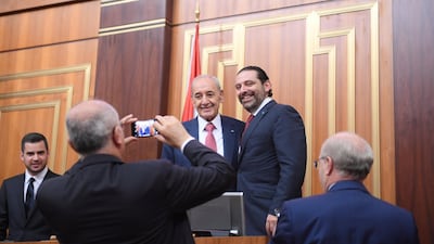 Lebanon's Finance Minister Ali Hassan Khalil takes photos of re-elected Parliament speaker Nabih Berri with Prime Minister-designate Saad Hariri at the parliament in Beirut on May 23, 2018. Reuters
