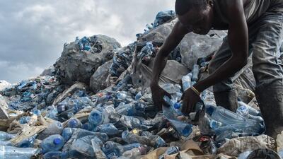 A man sorting out plastic PET bottles at the Kibarani dump site in Mombasa, Kenya. Andrew Kasuku / AFP