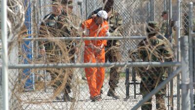 A detainee from Afghanistan is led by military police at Camp X-Ray at the US Naval Base in Guantanamo Bay, Cuba. It came to light recently that the CIA lied to the American public and to Congress about the extent of its use of “enhanced interrogation”, which is now accepted to be a form of torture. Lynne Sladky / AP Photo
