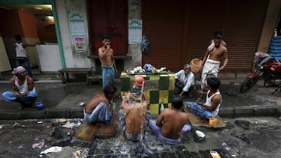 Men bathe at a roadside municipal water point.